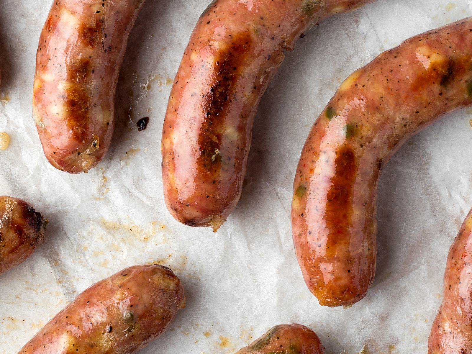 Cooked fresh sausages arranged on parchment