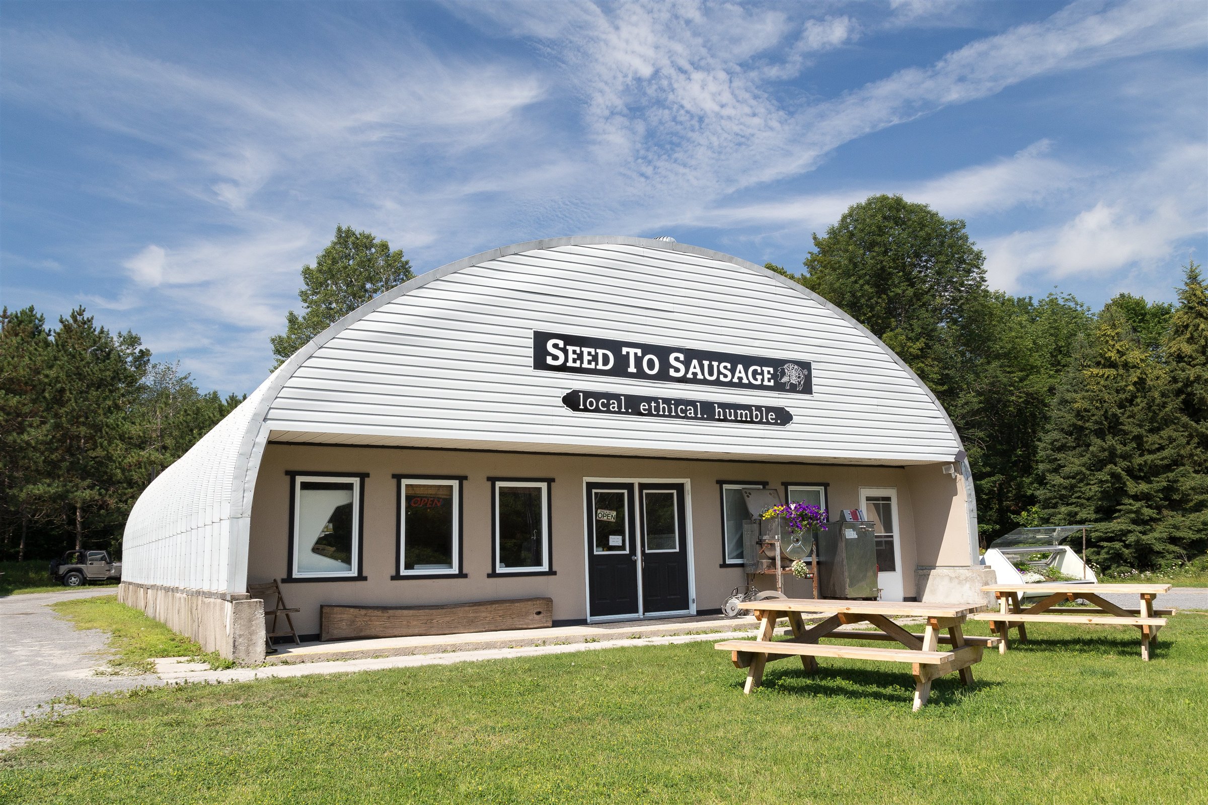 A Seed to Sausage building surrounded by trees