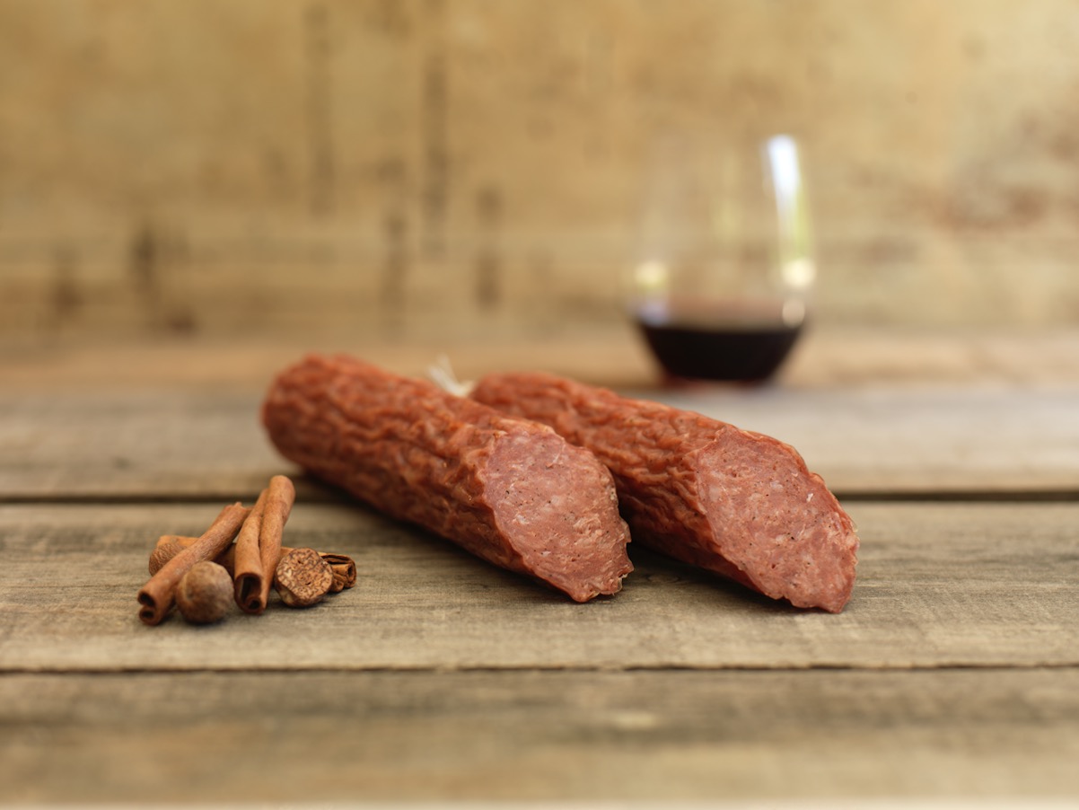 Genoa salami with sliced pieces on a wooden surface