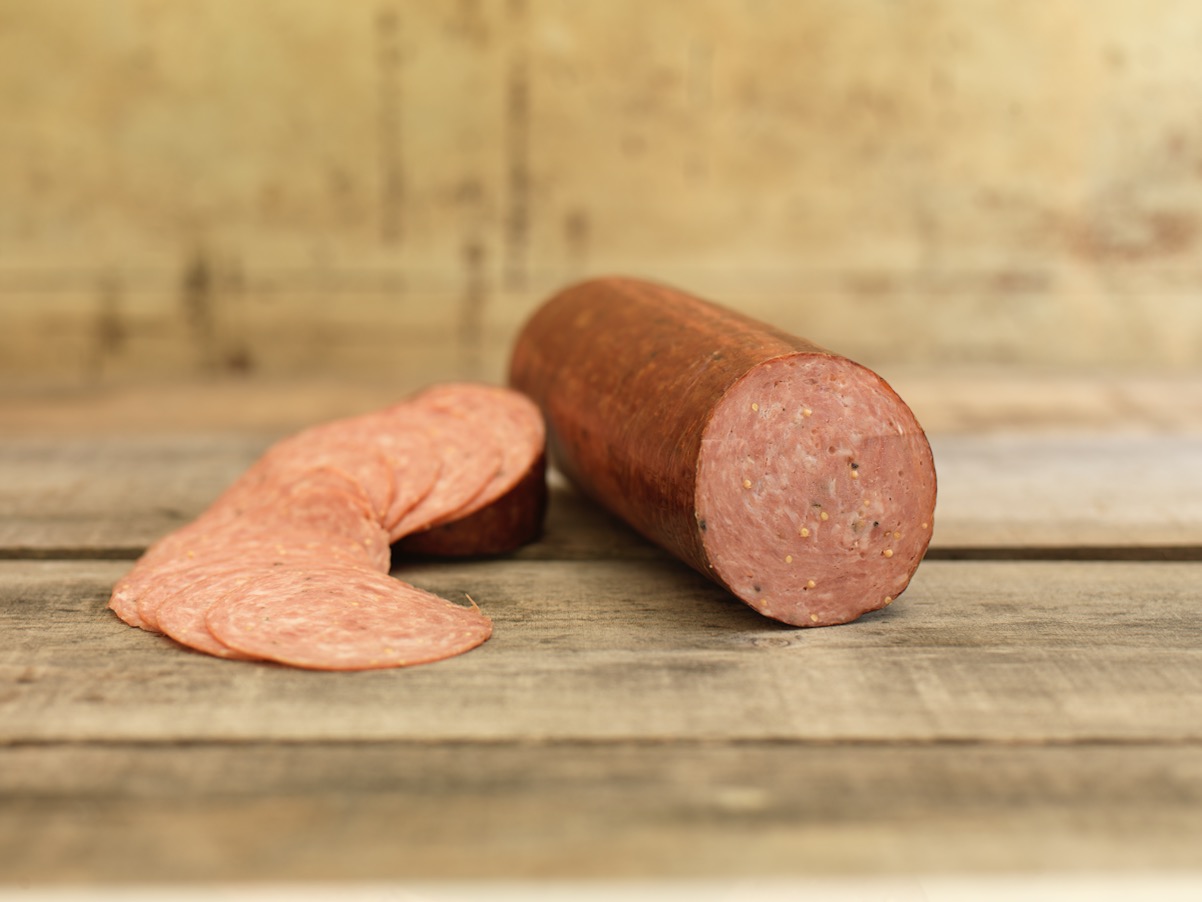 Hunters salami with sliced pieces on a wooden surface